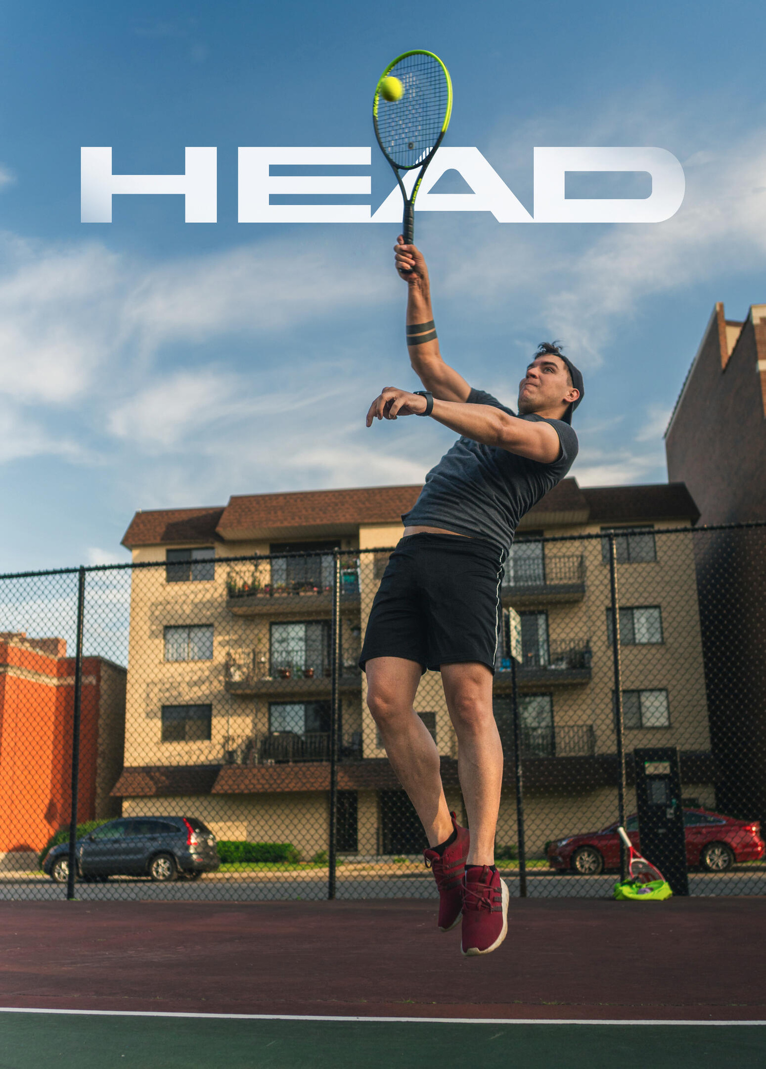 Photo of a tennis player hitting a tennis ball at the top of his jump.