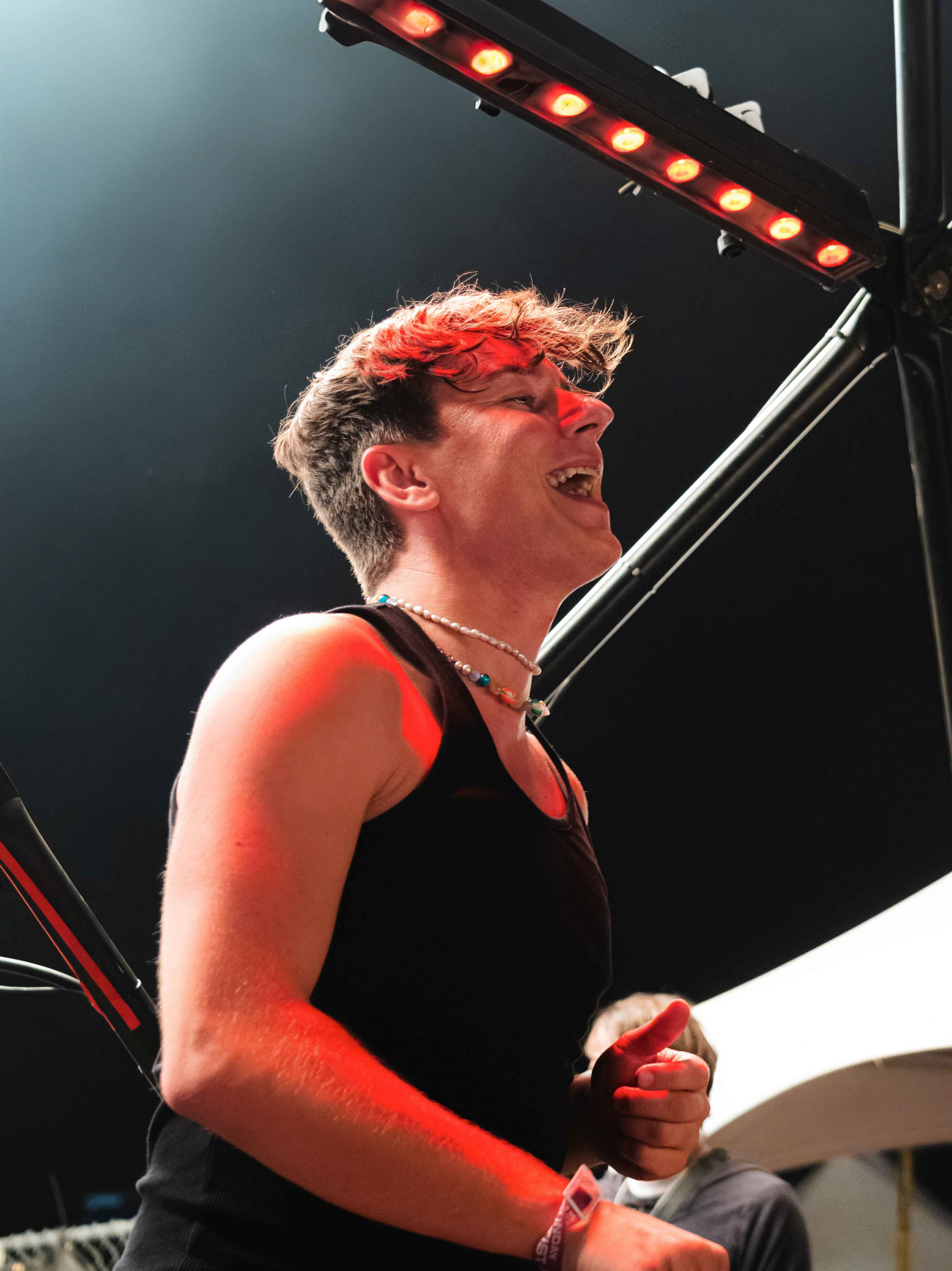 BUNT performing on stage at North Coast 2024, laughing with red lights glowing behind him.